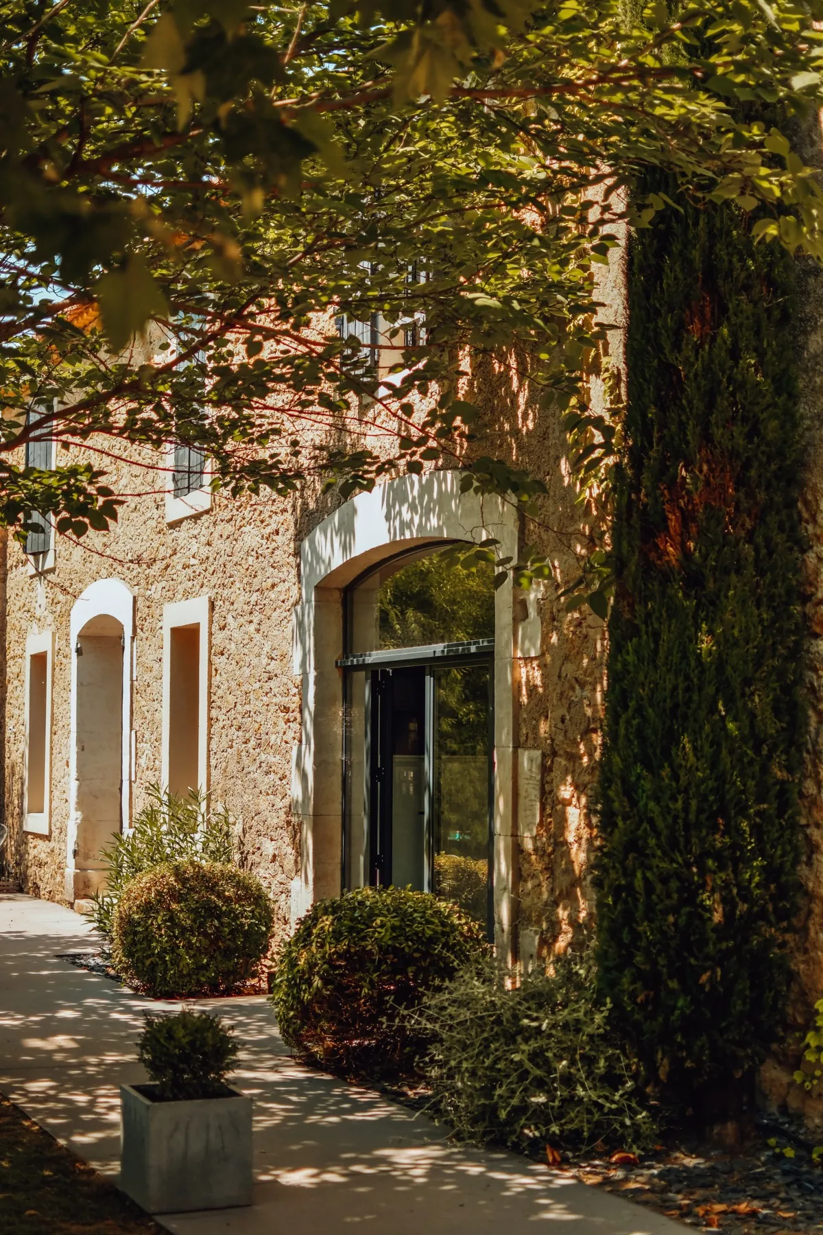 Entrée en pierre du mas sous les feuillages
