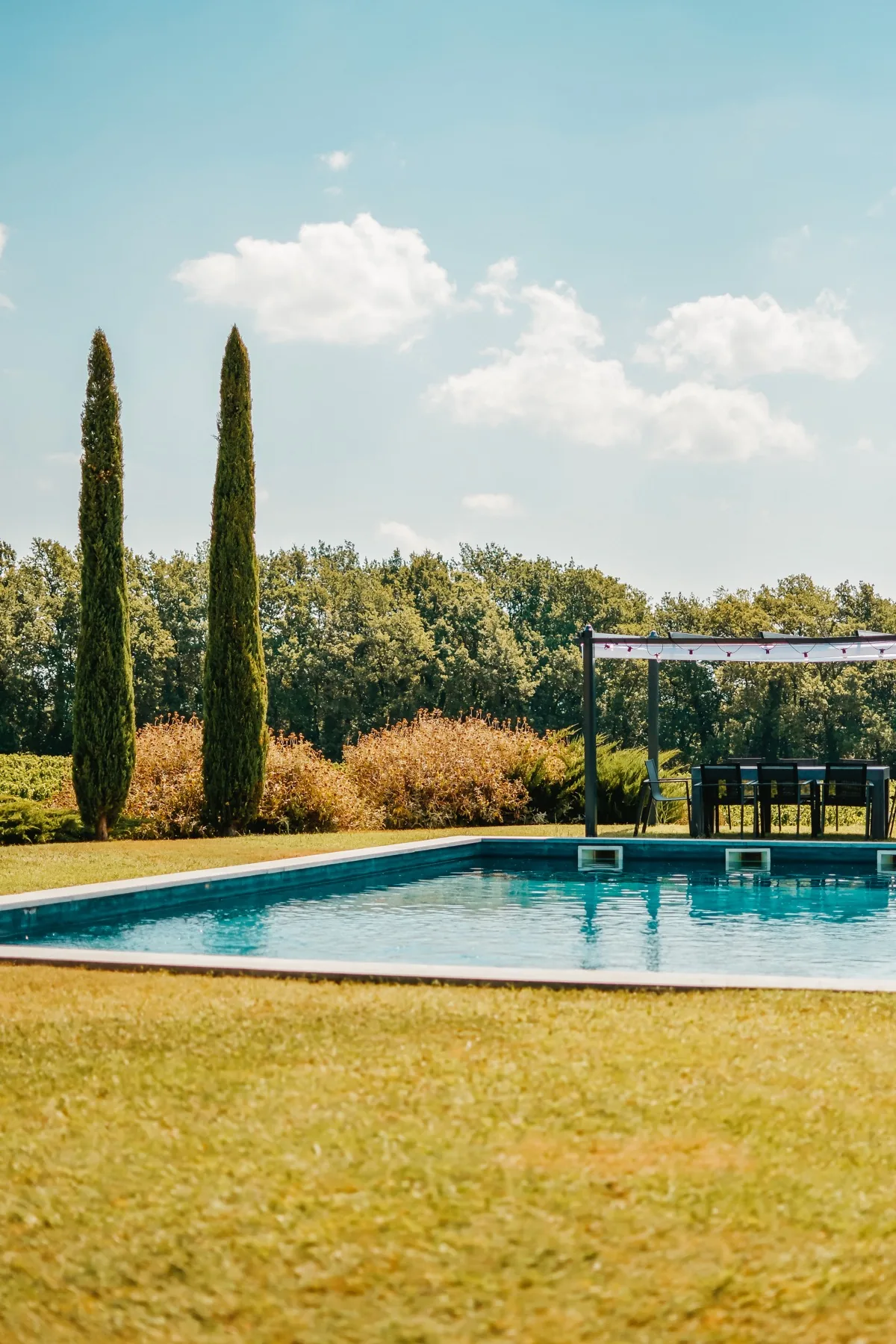 Piscine, cyprès et ciel clair dans l'esprit du Sud
